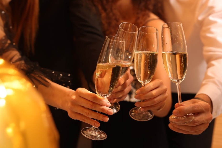 verschiedene Menschen stoßen mit Ihrem Glas Sekt an