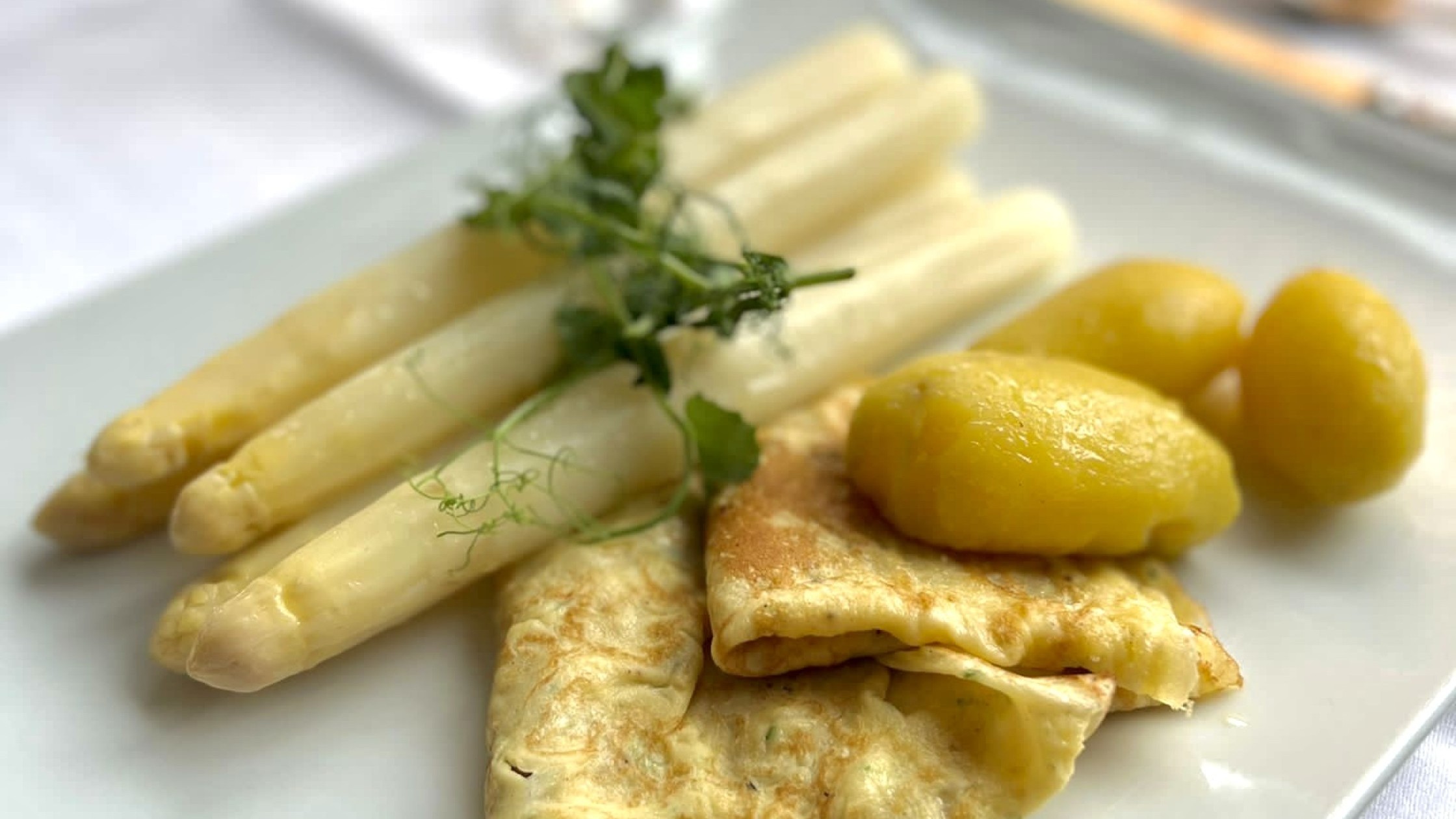 Spargel serviert mit Kartoffeln und Pfannkuchen