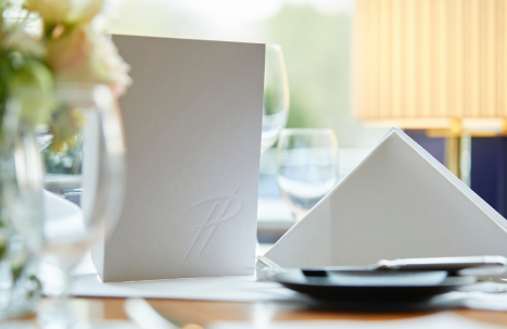 Eine Nahaufnahme eines Tisches im Parkrestaurant mit grauer Menükarte