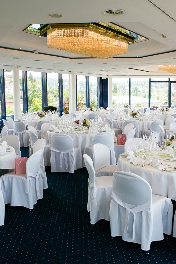 Runde Tische im Dachgarten für eine Hochzeit dekoriert mit weiß und rosa