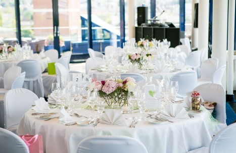 Runde Tische im Dachgarten für eine Hochzeit dekoriert mit weiß und rosa