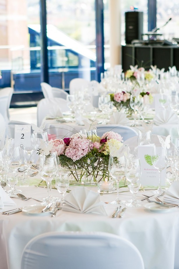 Runde Tische im Dachgarten für eine Hochzeit dekoriert mit weiß und rosa