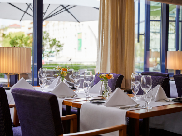Einzelner Tisch im Parkrestaurant mit blauem Stuhlpolster