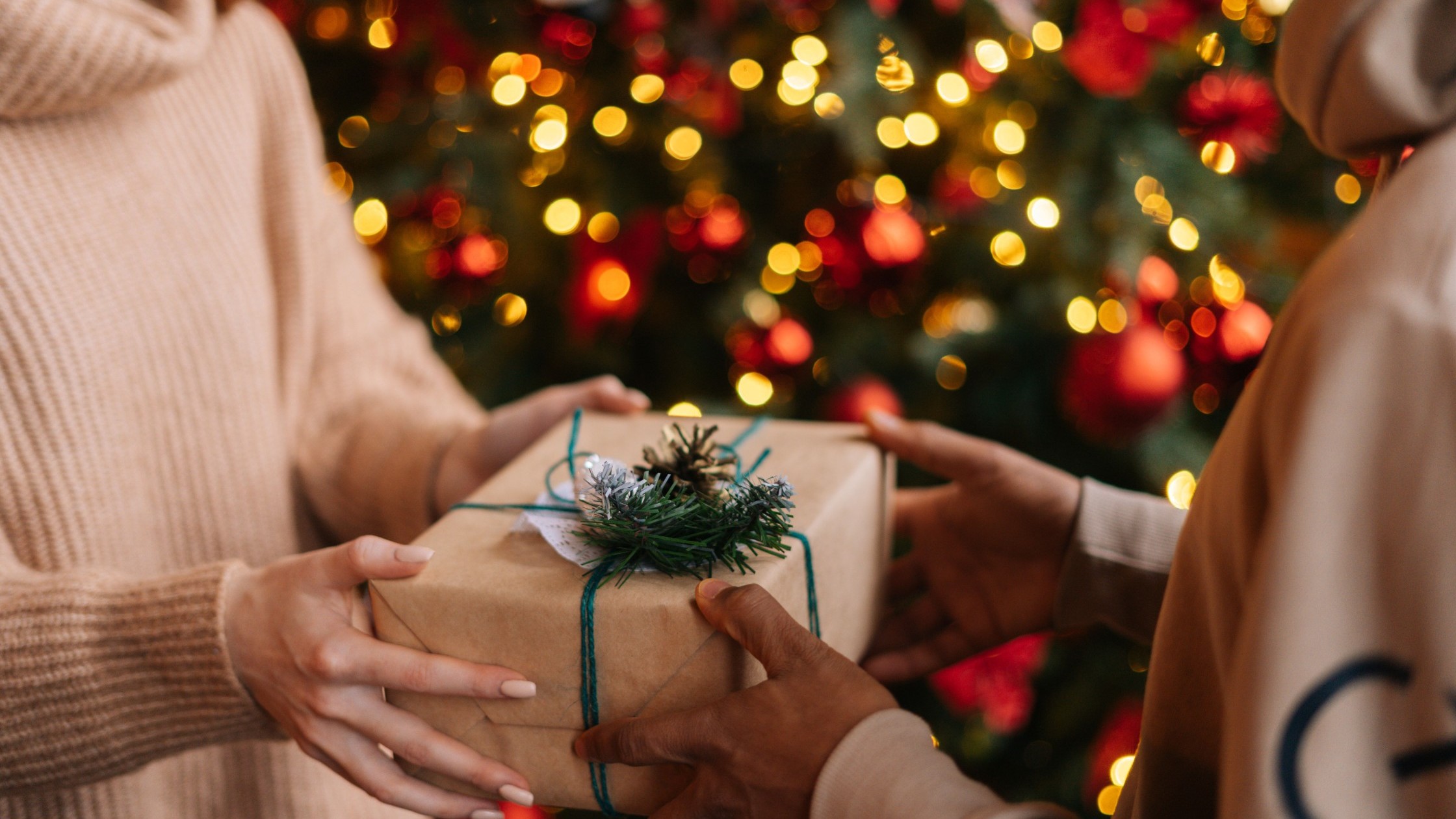 Zwei Menschen übergeben sich ein Weihnachtsgeschenk