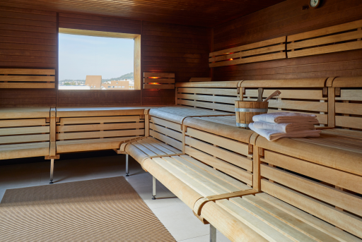 Finnische Sauna mit Holzbänken und einem Fenster mit Aussicht auf die Stadt