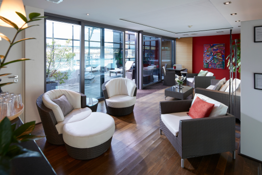 Innenbereich des Wellness mit gemütlichen Sitzgelegenheiten und Blick auf die Terrasse